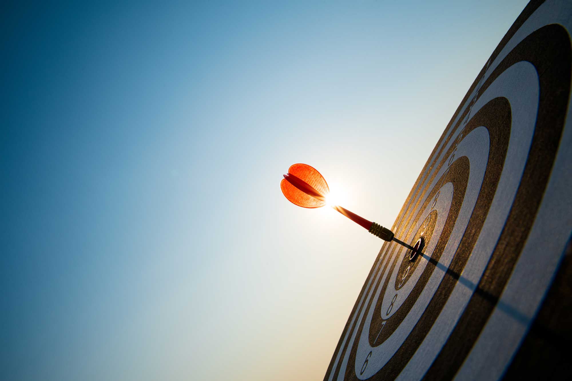 close-up-shot-red-darts-arrows-in-the-target-center-on-dark-blue-sky-background-business-target-or-goal-success-and-winner-concept